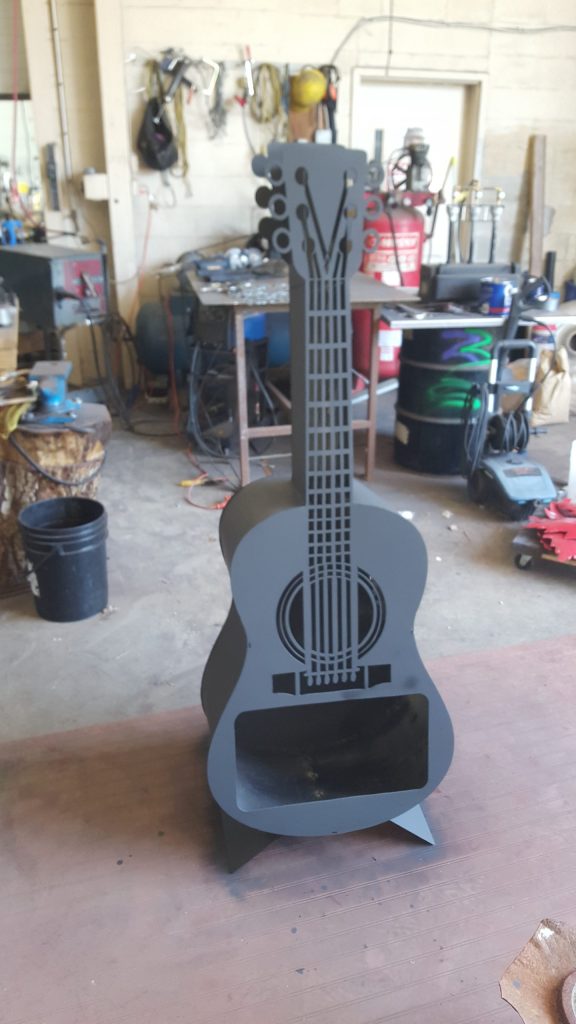 A guitar shaped fire pit that accumulates heat. JW Portable Welding & Repairs 2021, London, Ontario