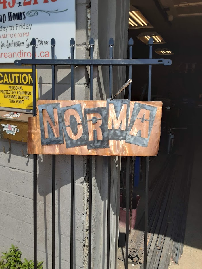 Fitting the sign to the left part of grills. The sign contains cut our letters and backing copper foil. JW Portable Welding & Repairs 2019, London, Ontario