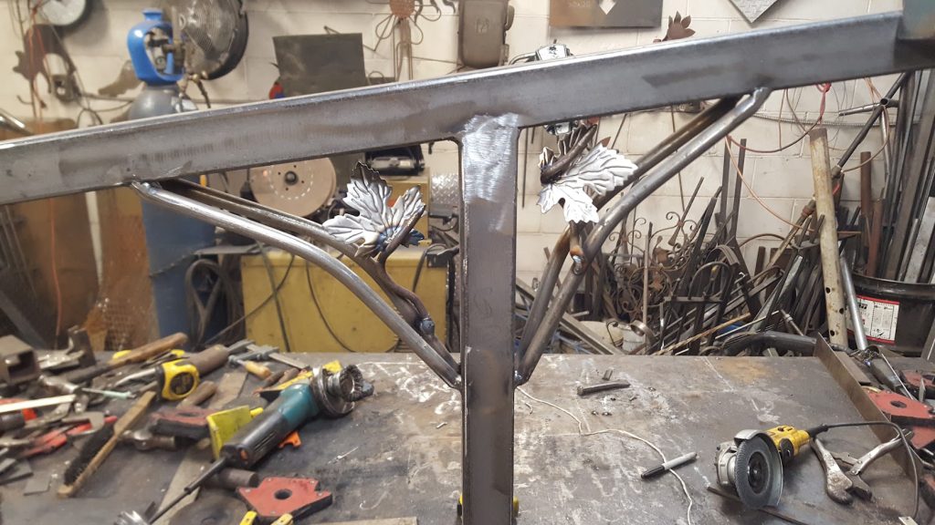 Unpainted outdoor handrail with wrought iron decorations and 2 maple leaves. JW Portable Welding & Repairs 2020 London, Ontario
