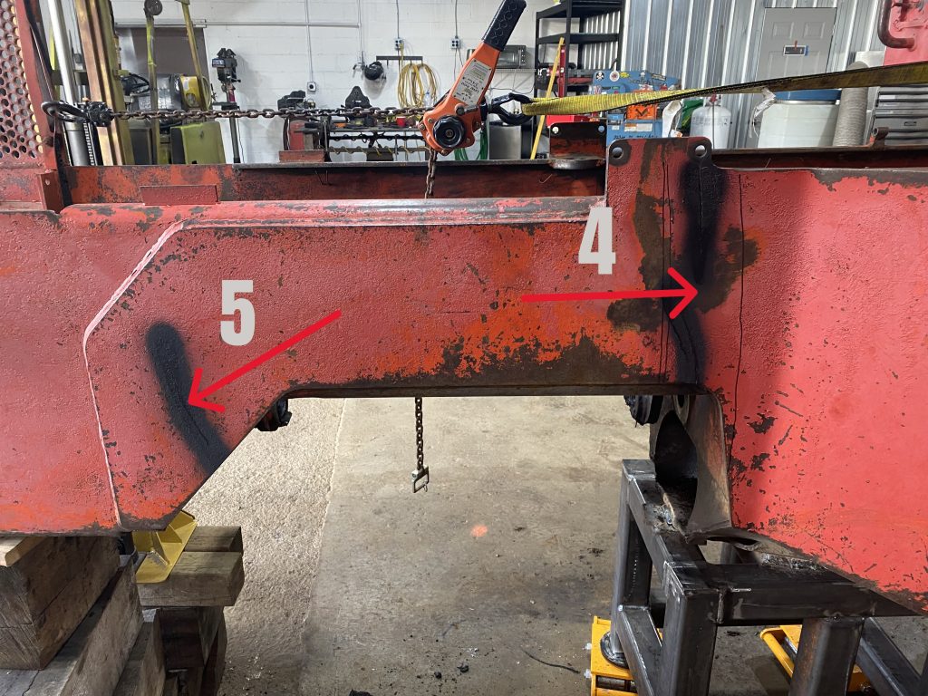 Cracks 5 and 4 as they are visible on the outside plate of the skidder's left hand side. Each crack is marked in black and with corresponding number and red arrows point to cracked area. August 11,2025 for JW Portable Welding & Repairs, Lucan Ontario