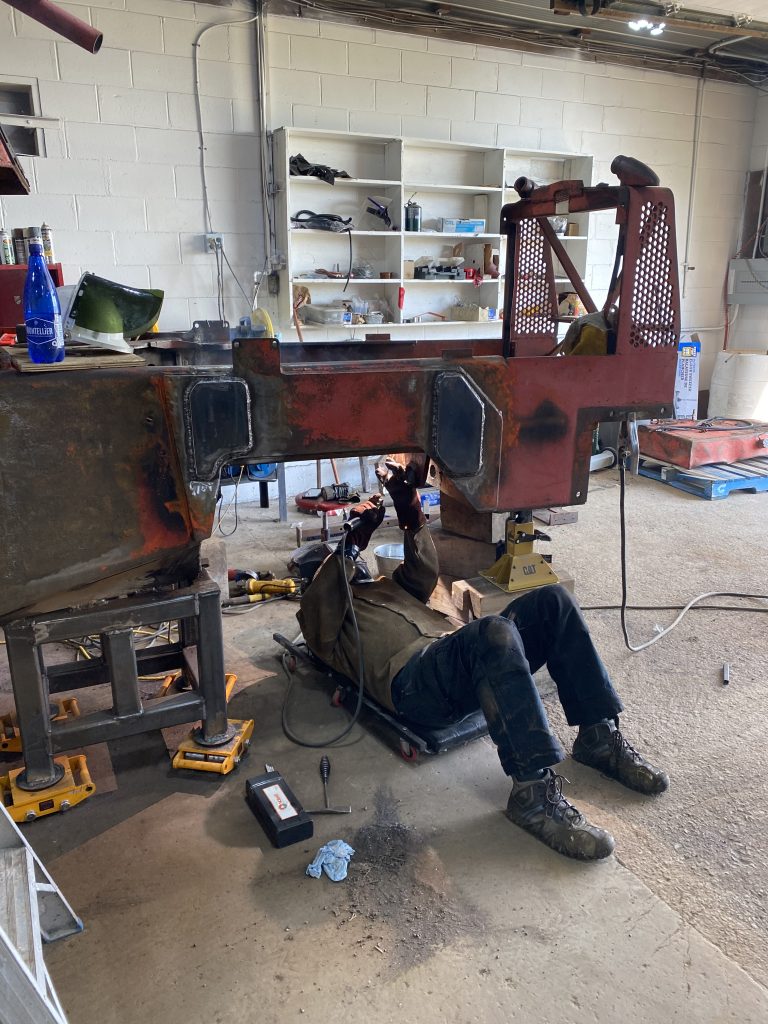 Welder is welding while laying on the creeper upside down V beveled crack in horizontal plate with high tensile rods. The temperature monitoring system has been removed. August 14, 2025, for JW Portable Welding & Repairs, Lucan Ontario