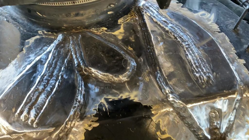 Three fish plates welded to the base material in heavy equipment repair process. The two fishplates are slotted. The additional small fishplate covers newly found crack. Top view. JW Portable Welding & Repairs, London Ontario, January 2, 2022