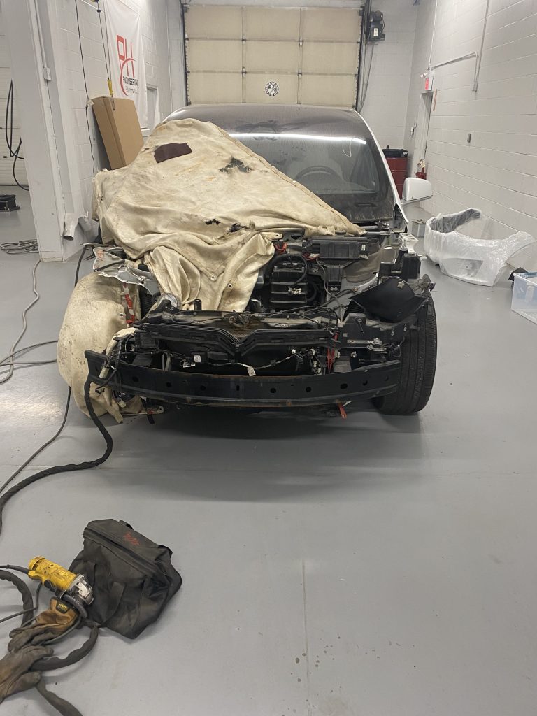 Front of Tesla Model X 100D after thunder bender. Client has removed the external movable panels and will repair this car himself due to high cost of repair in Tesla body shop. The front end of the car has no body panels and is covered with fire blankets. December 6, 2023 for JW Portable Welding & Repairs, Aylmer Ontario