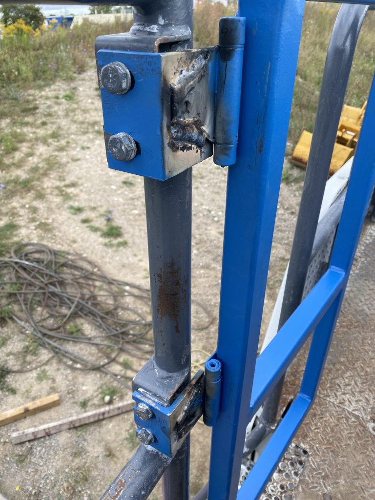 Installed new gate with self closing hinges eliminates the fall hazard. View from the hinge side where welding of hinges is visible. The gate is in closed position.