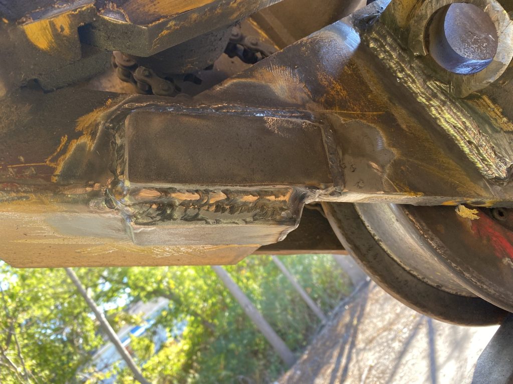2 Fishplate welded on the section connecting the left wheel side frame with railway crane structure. Each fishplate covers repaired by welding cracks in structural steel of railway crane. All around welded fishplates will prohibit crack spreading. London ON, 2024, JW Portable Welding & Repairs.