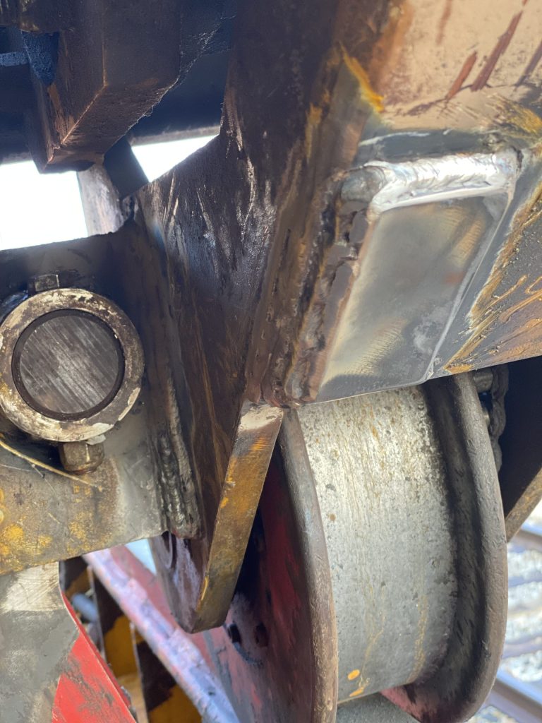 The left wheel with vertical weld on the wheel's side frame with locating pin installed. The fishplate is welded with all around weld that will prohibit crack spreading in the structure of the railway crane. London ON, 2024, for JW Portable Welding & Repairs