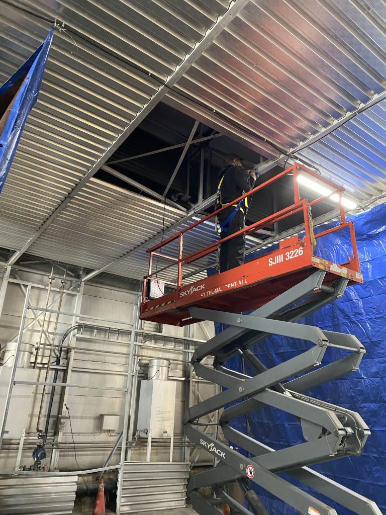 Worker on a scissor lift works on Open Web Aluminum Joist. For JW Portable Welding, 2025, St. Thomas