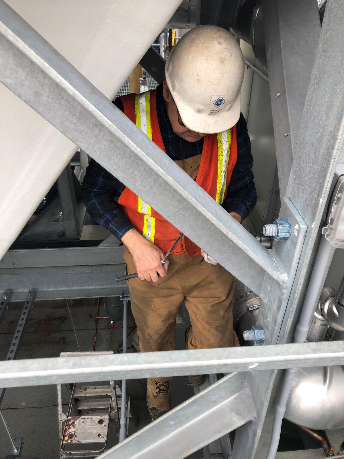 Some climbing is necessary when for on site inspection of leaks on large aluminum HVAC. On site inspection requires some level of physical fitness. JW Portable Welding & Repair 2020 London, Ontario.