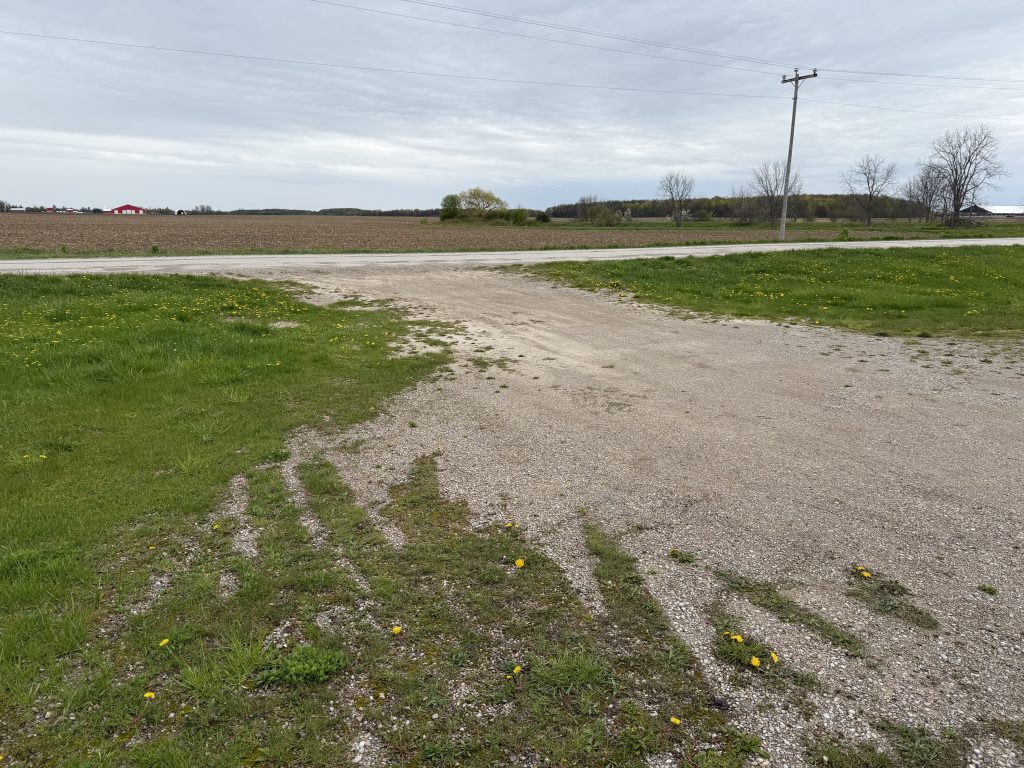 Old gravel driveway in leading to welding shop in Lucan. The old driveway is 14 feet wide and has steep slope from the road. making turns very difficult with heavy equipment. For JW Portable Welding & Repairs, 2026, Lucan