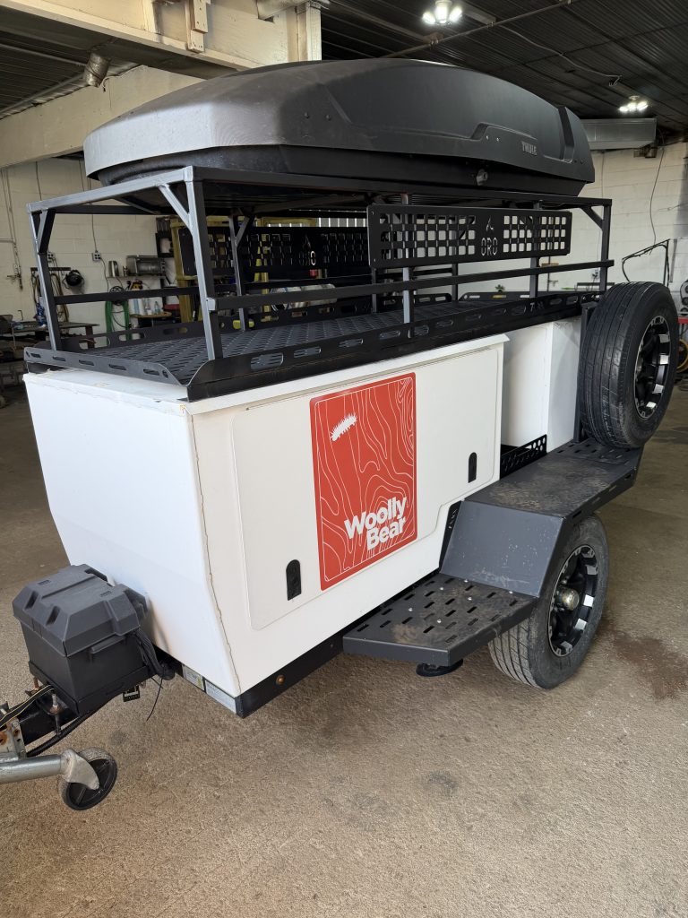 The new metal fabricated rack on the trailer is much higher and it is wider. It allows for sleeping on top of the trailer. Designed and fabricated by JW Portable Welding & Repairs, Lucan, 2026
