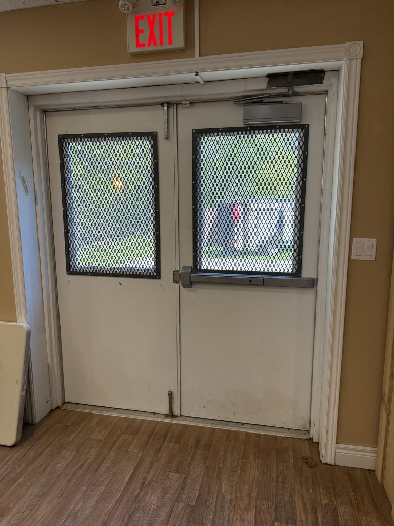 Two inside window nets on metal doors protect the door windows against burglars. The crushed expended metal is 1/8 inch thick. Metal fabrication by JW Portable Welding & Repairs, 2025, London.