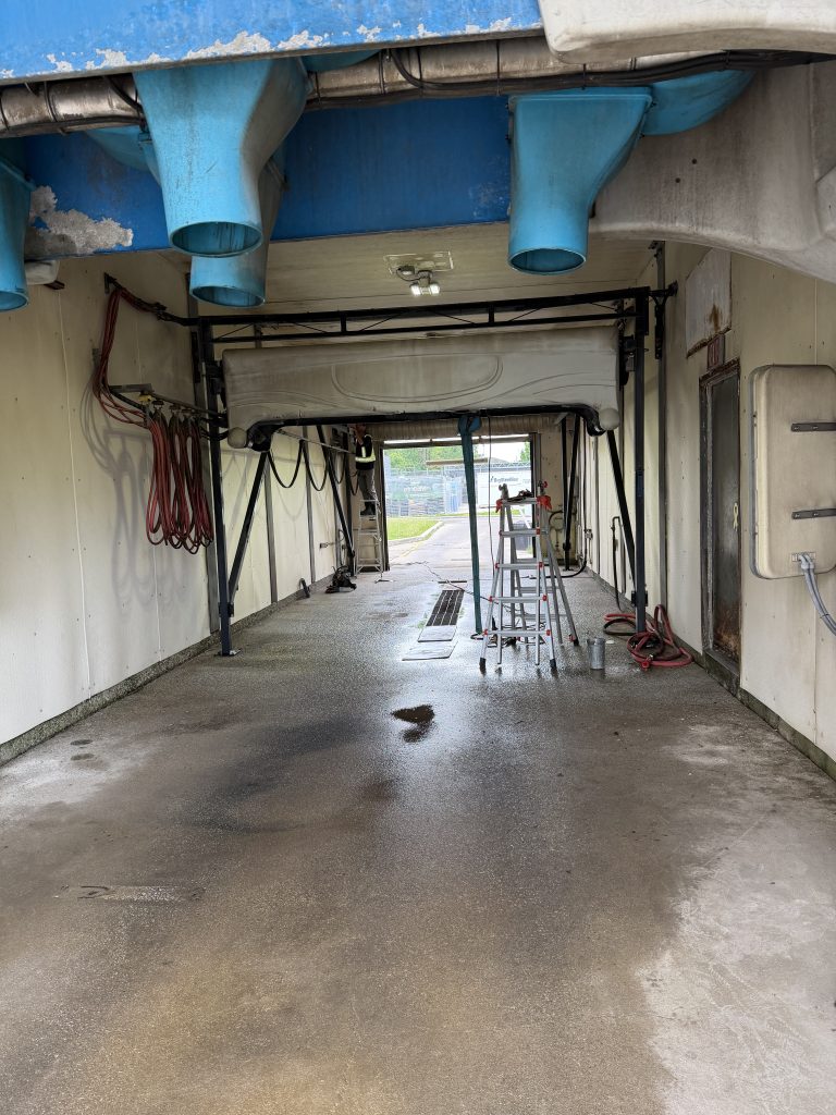 Car wash equipment repair. Inside of the small carwash where we will weld their equipment. The ladder points to the equipment being repaired. For JW Portable Welding & Repairs, 2026, London