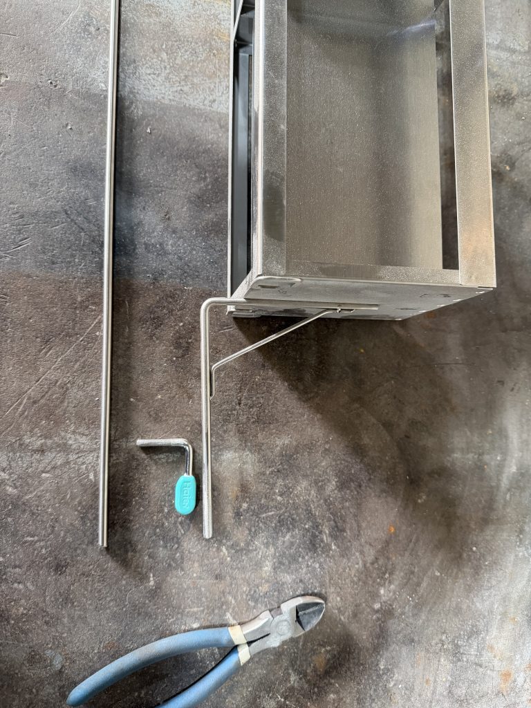 Laboratory equipment repair. The modification of this laboratory equipment's handle will involve the small piece in the middle with the green plastic, old stub handle attached to modified equipment and new stock located to the left. For JW Portable Welding & Repair , 2026, London