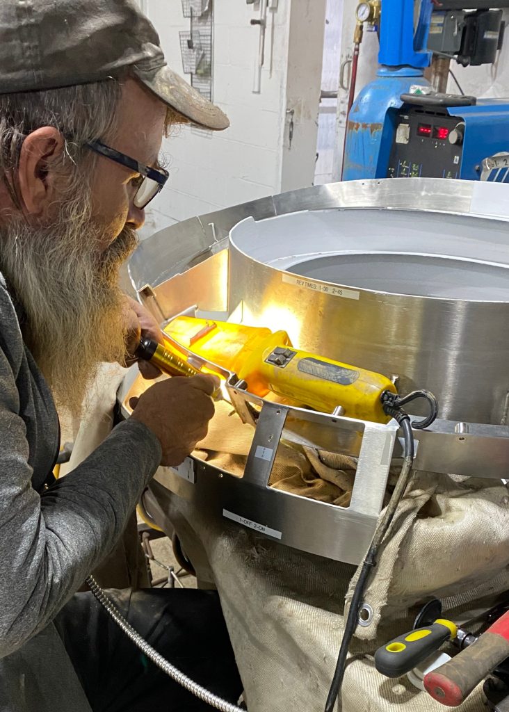Medical equipment repair. The worker with the micro grinder polishes the sharp edges in 318 stainless that left after welding in difficult to reach areas. For JW Portable Welding & Repairs, Lucan, 2025