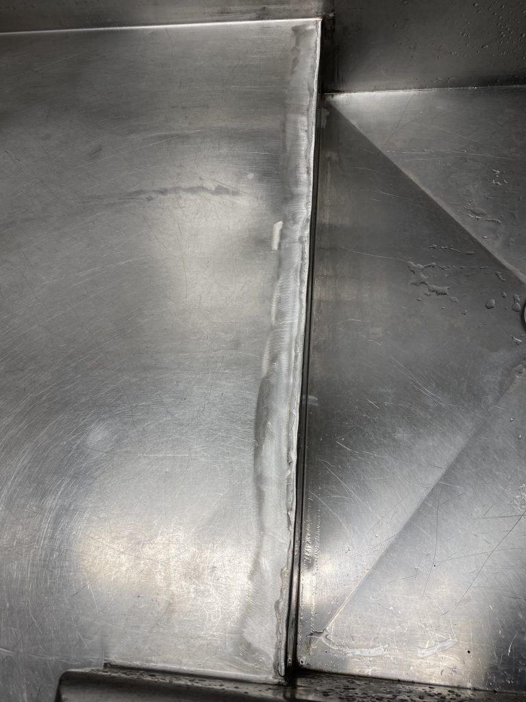 Mobile GMAW stainless steel welding service on sink in community center. Welded edge of commercial stainless sink after polishing. For JW Portable Welding & Repair, 2025, London